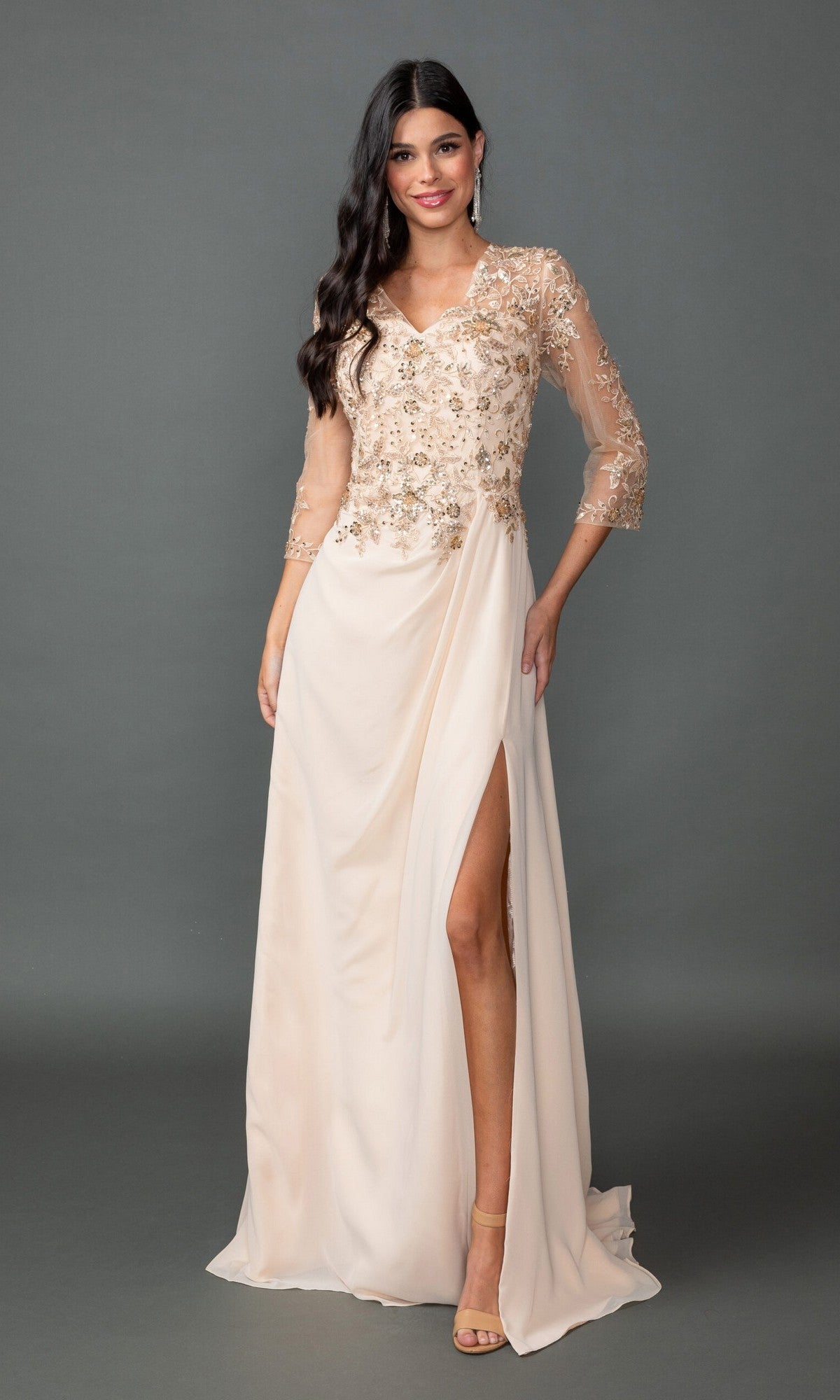 A woman models the Dancing Queen 4543 long formal dress with a sequin lace bodice, sheer three-quarter sleeves, an A-line skirt, and a high slit, standing before a gray backdrop.